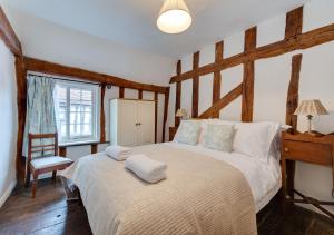 a bedroom with a large bed with wooden beams at Coppers in Lavenham