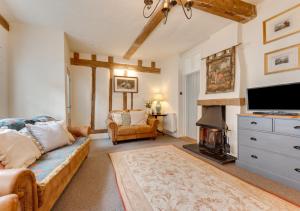 a living room with a couch and a fireplace at Coppers in Lavenham