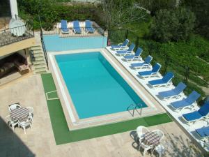 an overhead view of a swimming pool with lounge chairs and a pool at Gultepe Apartments in Kuşadası