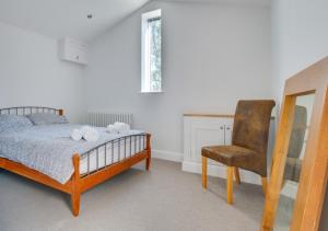 a bedroom with a bed and a chair at Daisy Lodge in Blyford