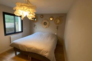 een slaapkamer met een bed, een raam en een kroonluchter bij VILLA 8 pièces LA COLOPHANE AVEC PISCINE in Arcachon