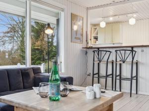 cocina y sala de estar con mesa y botella. en Holiday Home Arho - 75m from the sea in Funen by Interhome, en Spodsbjerg