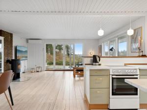 cocina abierta y sala de estar con suelo de madera en Holiday Home Arho - 75m from the sea in Funen by Interhome, en Spodsbjerg