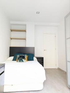 ein Schlafzimmer mit einem weißen Bett und weißen Schränken in der Unterkunft m-odern in Sevilla