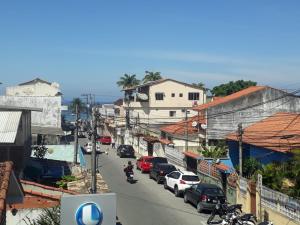 Loft PARIS para Casais, em Iguaba Grande, 150 metros da praia في إيغوابا غراندي: شارع المدينة فيه سيارات تقف على جانب الطريق