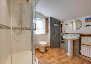 uma casa de banho com um chuveiro, um lavatório e um WC. em Dressmakers Cottage em Wrentham