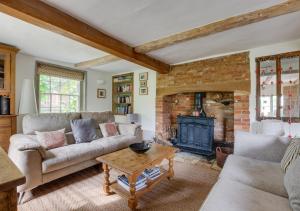 uma sala de estar com um sofá e uma lareira em Dressmakers Cottage em Wrentham