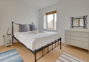 1 dormitorio blanco con 1 cama grande y vestidor en Dunlin en Southwold