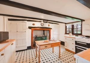 Hemley的住宿－Eelsfoot Cottage，厨房中间设有桌子