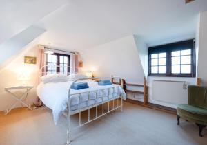 um quarto com uma cama e uma cadeira em Eelsfoot Cottage em Hemley