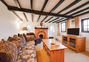 a living room with a couch and a tv at Eelsfoot Cottage in Hemley