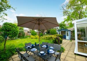 een patio met een tafel en een parasol bij Fallowfield in Reydon