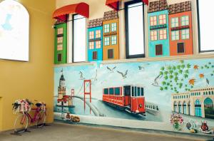 a mural on the wall of a building with a train at Qala Hostel Ganja in Ganja