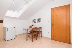a dining room with a table and a wooden door at Apartments Karolina in Novalja