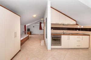a kitchen with white cabinets and a sink at Apartments Karolina in Novalja