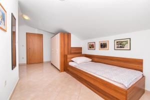 a bedroom with a wooden bed and a cabinet at Apartments Karolina in Novalja