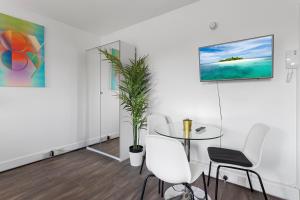 a dining room with a table and white chairs at Exeter City Centre Apartments Eden Apartment in Exeter