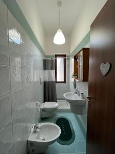 a bathroom with two sinks and two toilets at Il Grande Ulivo in Selva di Fasano