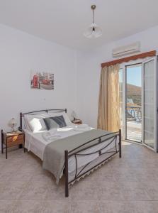 um quarto com uma cama e uma grande janela em The Panorama House em Pera Gyalos