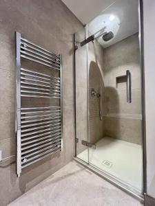 La salle de bains est pourvue d'une douche avec une porte en verre. dans l'établissement The Apartments Lytham Square, à Lytham St Annes