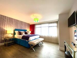 a bedroom with a blue bed and a window at Stunning 3 bedroom Penthouse Apartment - Free Parking & WiFi - 1 Minute walk to Poole Quay - Great Location - Free Parking - Fast WiFi - Smart TV - Newly decorated - sleeps up to 6! Close to Poole & Bournemouth & Sandbanks in Poole