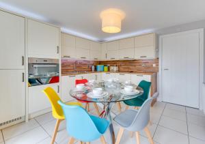 a kitchen with a glass table and chairs at Felsto Beach in Felixstowe