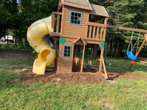 a play house with a slide in a yard at dôme près du lac in Saint-Narcisse-de-Rimouski