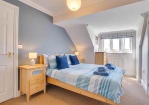 a bedroom with a bed with blue pillows at Field End in Reydon