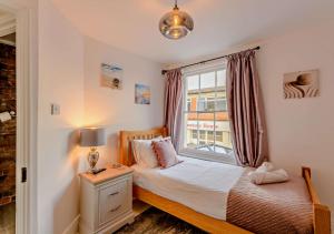 a bedroom with a bed and a window at Harbour Cottage - Ramsgate in Ramsgate