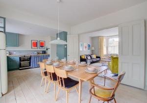 a kitchen and living room with a wooden table and chairs at Fern Cottage in Walberswick