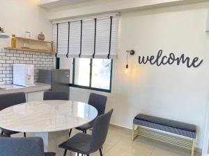 マラッカにあるGracious ~ Walking Distance to SEE, SHOP and EATのダイニングルーム(テーブル付)、壁にウェルカムサイン