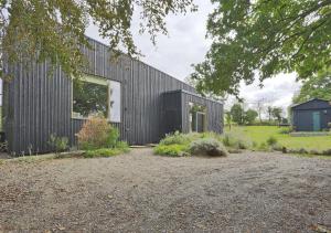 a black clad house with a garden in front of it at Glenview in Bramfield