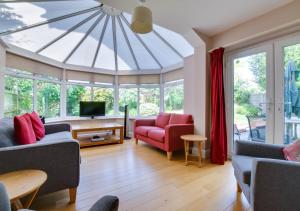 una sala de estar con un gran techo de cristal en Gleve House en Marlesford