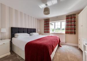 a bedroom with a large bed with a red blanket at Gleve House in Marlesford