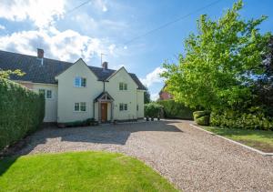 een groot wit huis met een grindoprit bij Gleve House in Marlesford