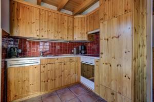a kitchen with wooden cabinets and a sink at Chalet OnThePiste in La Tzoumaz +19 photos