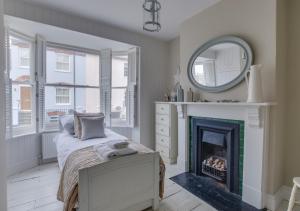 a bedroom with a bed and a mirror and a fireplace at Hanover House in Aldeburgh