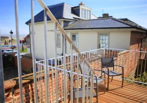 a deck with a chair and a house at Hanover House in Aldeburgh