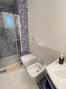 uma casa de banho com um chuveiro, um WC e um lavatório. em Casa dei Visionari 2 em Bari
