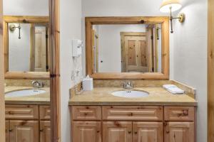 a bathroom with two sinks and two mirrors at Telluride Mountain Lodge Skiin Out amazingLocation in Telluride