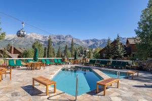 a swimming pool with tables and chairs and mountains at Telluride Mountain Lodge Skiin Out amazingLocation in Telluride