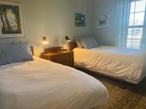 ein Schlafzimmer mit 2 Betten und einem Tisch mit einer Lampe in der Unterkunft Heated, Private Pool in Quiet Midtown Neighborhood in Hattiesburg