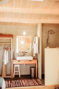 een badkamer met een wastafel en een spiegel bij Cabanas de Melides in Melides