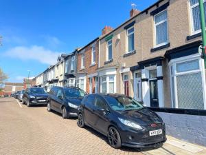 uma fila de carros estacionados ao lado de uma rua em Mini-studio by HNFC Stays em South Shields