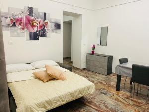 a bedroom with two beds and a table and a desk at Le Regioni Del Cuore in Vieste