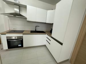 una cucina con armadietti bianchi e piano cottura di Be Chic ad Alba Adriatica