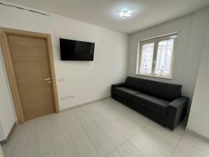 a living room with a couch and a flat screen tv at Be Chic in Alba Adriatica