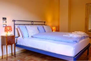 een bed met blauwe lakens en kussens in een kamer bij Le Case Gialle in Gualdo Cattaneo