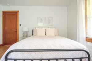 a white bedroom with a large bed in a room at Pine Grove Cottage in Chambersburg