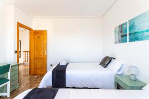 a bedroom with two beds and a door at Casa Las Rosas in Iniesta